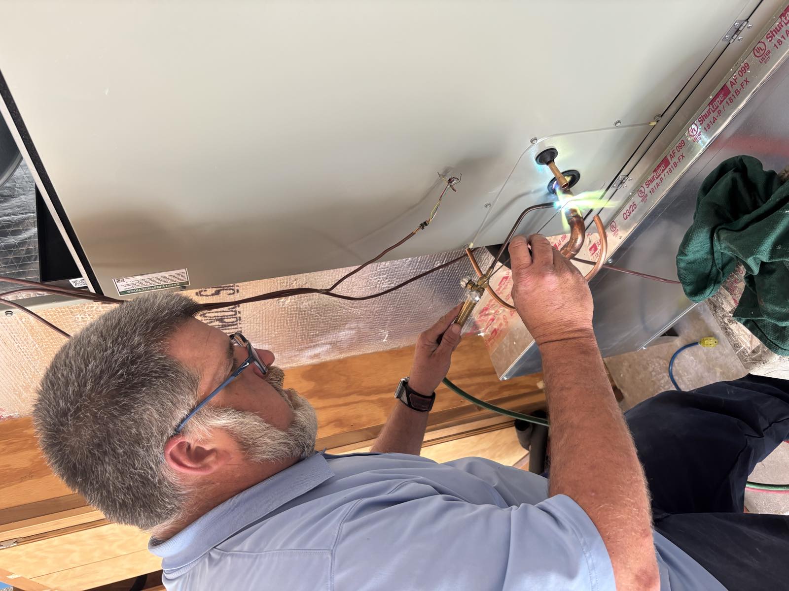 Technician brazing copper line set on a new air handler near Jacksonville