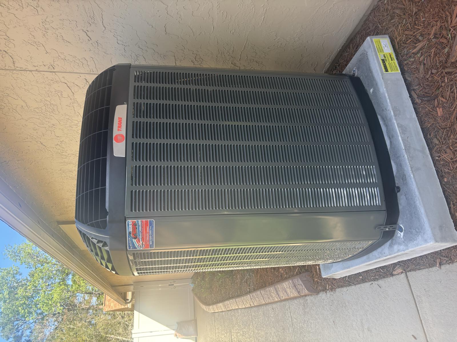 New Trane condenser with model sticker installed by Ideal Conditions at a Jacksonville home