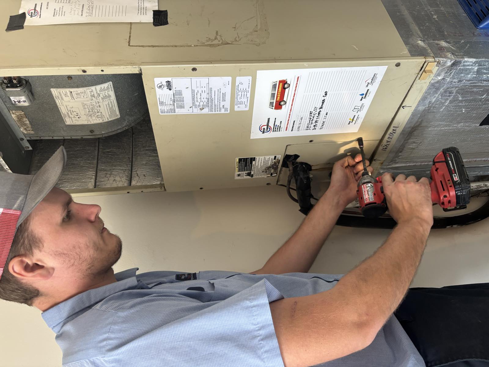 Ideal Conditions technician performing a maintenance tune-up on an air handler in Jacksonville