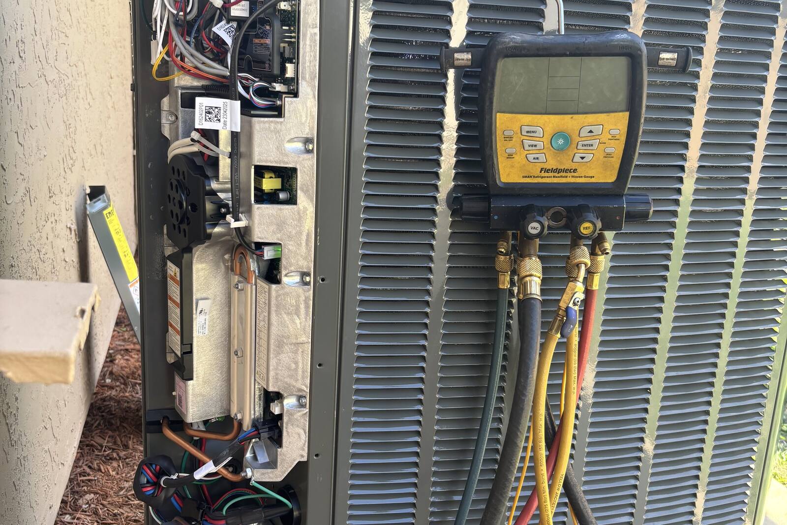 HVAC technician inspecting an aging AC condenser in a Jacksonville driveway