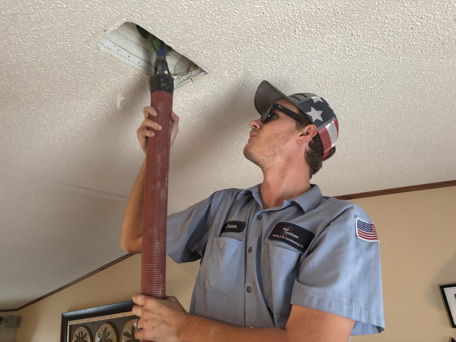 Ideal Conditions technician vacuuming a residential supply vent during a Jacksonville duct cleaning