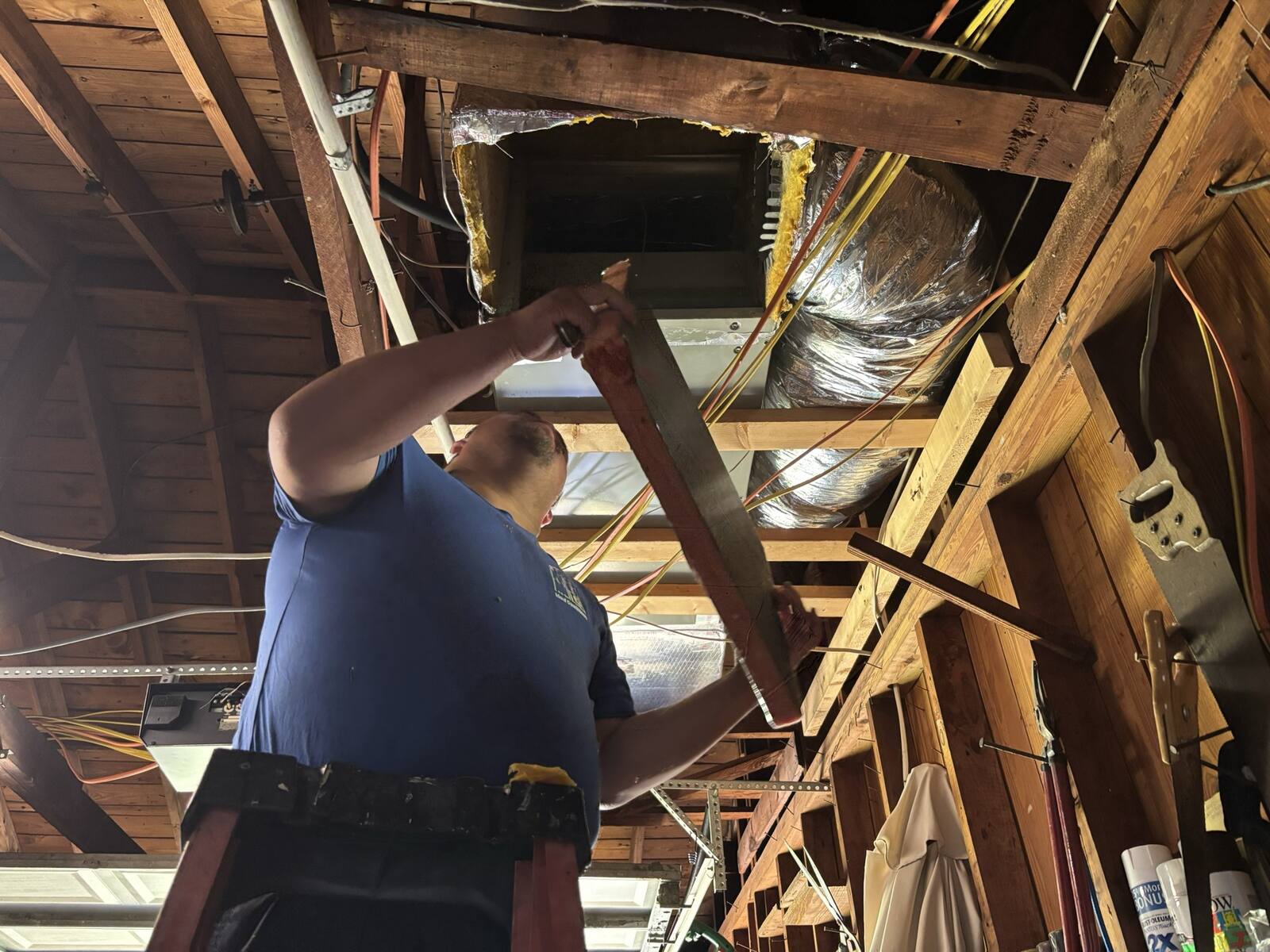 Ideal Conditions technician inspecting an open air handler in a Jacksonville home