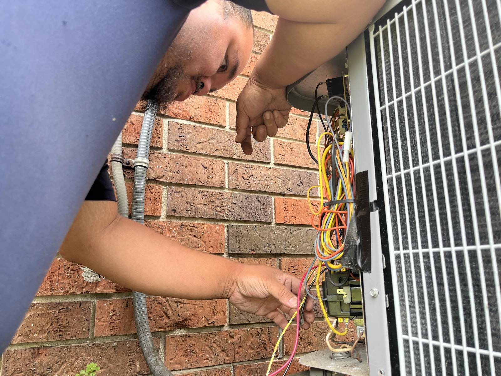 Ideal Conditions technician diagnosing a failed AC condenser's wiring during an emergency call in Jacksonville