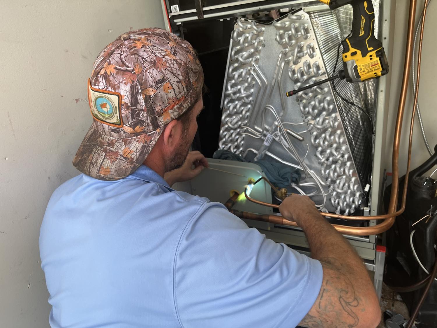 Ideal Conditions technician brazing copper onto a new residential heat pump air handler in Jacksonville